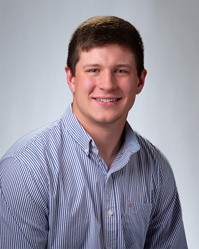 Man smiling wearing a blue and white striped shirt and is a farm and ranch appraiser at Premier Farm Credit