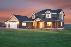 Large rural home at twilight with the lights on, financed by Premier Farm Credit, with real estate loans and rural area home mortgage loans