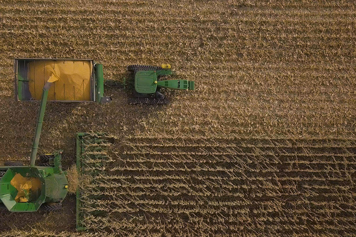 Combine emptying corn onto grain cart as seen from above