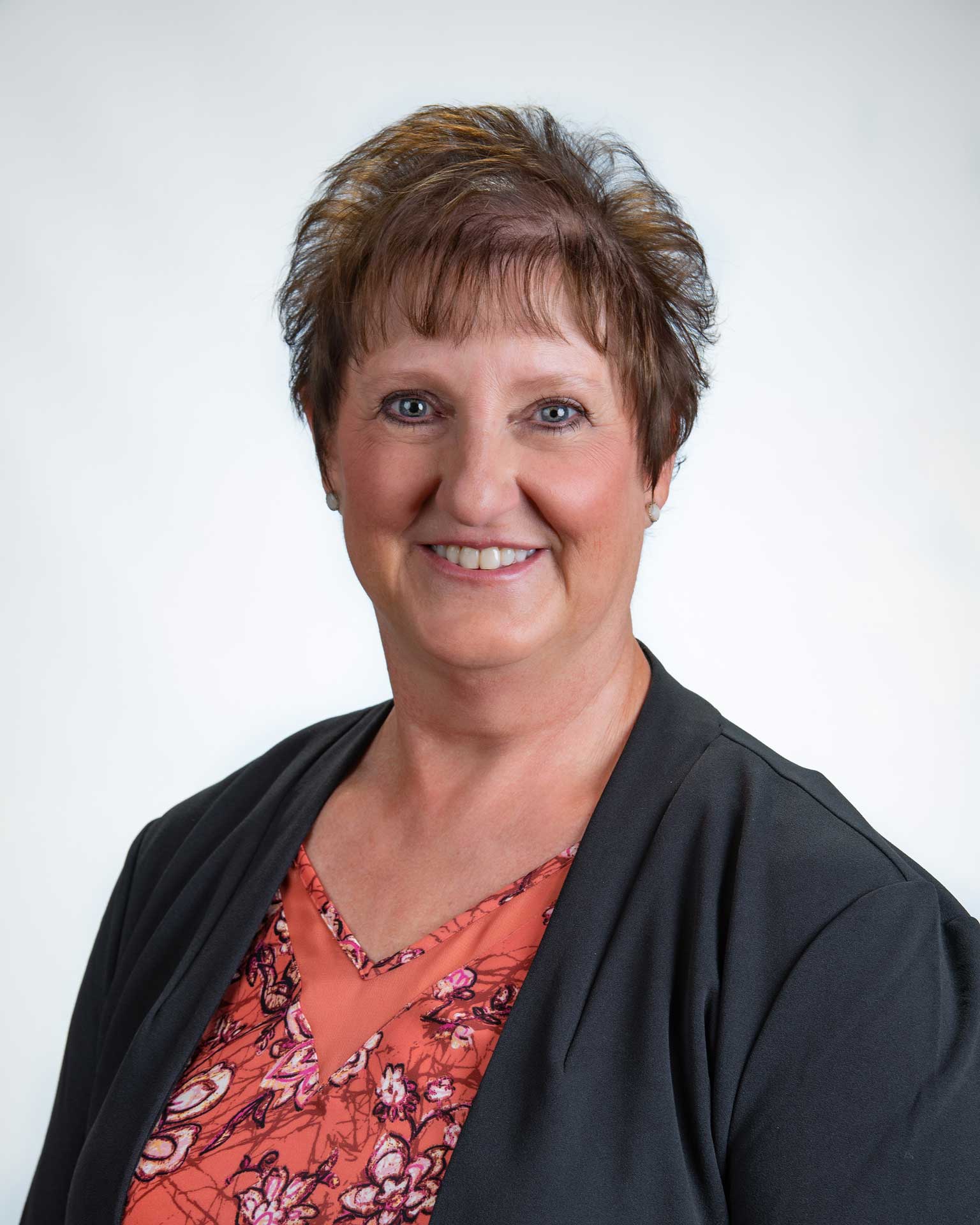 Woman wearing red sitting inside of Premier Farm Credit, offering farm, crop, and life insurance